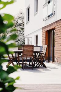 a wooden table and chairs on a patio at Apartamenty Miły - Gdynia Redłowo in Gdynia