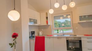 a kitchen with white cabinets and a red towel on the counter at Sea & Sun 4* in Banjole