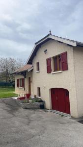 une maison avec des portes rouges et un garage dans l'établissement Au Grés du Vent, à Ruy