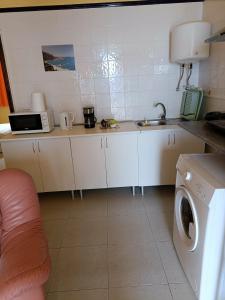 a kitchen with a sink and a washing machine at vista al mar. in Caleta de Interián