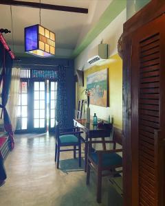 uma sala de jantar com mesa e cadeiras e uma luz em Red Coconut Villa em Bentota