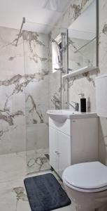 a white bathroom with a toilet and a sink at MODERN House in Sighetu Marmaţiei