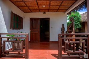 una entrada a una casa con puertas y bancos de madera en RELAIS DU KIRINDY, 