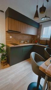 a kitchen with green cabinets and a table with a chair at Marina Zeas Seaside Studio-MarinaQ in Piraeus +26 photos