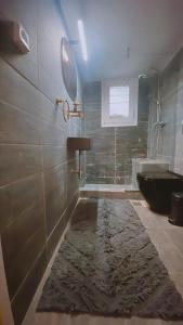 uma casa de banho com um lavatório, uma banheira e um tapete em Marina Zeas Seaside Studio-MarinaQ em Pireu