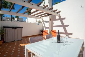 een witte tafel met wijnglazen op een patio bij Beautiful 2 Bedroom Bungalow with Communal Pools in Villamartin