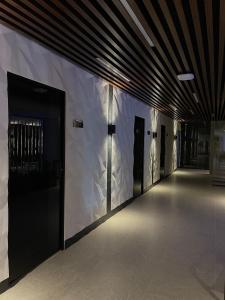 un pasillo con puertas negras y una pared blanca en BAYKA - SPA resort en Kosiv