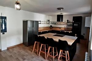 een keuken met een houten tafel en zwarte stoelen bij La cachette - Maison centre in Mulhouse