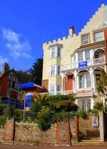 een groot wit gebouw aan de straatkant bij Hotel Hudson in Torquay