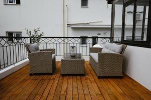 two chairs and a table on a balcony at LB Luxury Apartments in Volos