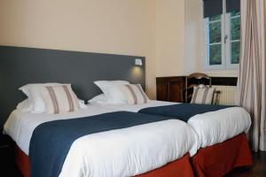Ein Bett oder Betten in einem Zimmer der Unterkunft Logis Hôtel du Chêne