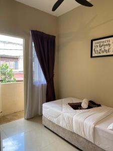 um quarto com uma cama e uma janela em Four Rooms Homstay 'A' With Wifi And Smart TV in Wakaf Tapai 