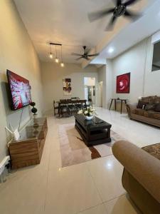 uma sala de estar com um sofá e uma mesa em Four Rooms Homstay 'A' With Wifi And Smart TV in Wakaf Tapai 