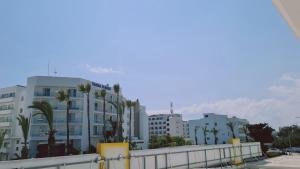 a group of buildings with palm trees in the background at STAY Nissi Gusto 2 in Ayia Napa