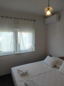 a bedroom with a white bed and a window at Villa The Cave in Blagaj