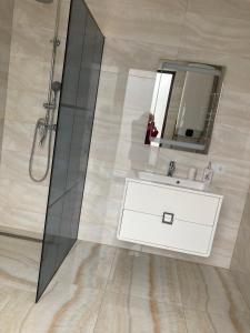 La salle de bains est pourvue d'un lavabo blanc et d'un miroir. dans l'établissement Котедж Golden Lemon, à Mijgiria