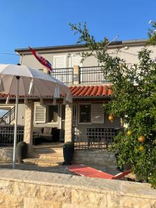 a house with an umbrella in front of it at Apartments Stone in Vrsi