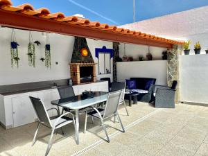a patio with a table and chairs and a fireplace at Casa dos Montes in Alvor