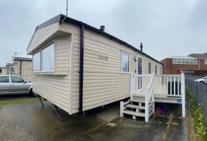 a tiny house with a staircase in a parking lot at Coastfields 3 bed 8 berth holiday home in Ingoldmells