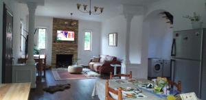 a kitchen and living room with a table and a refrigerator at Cold Spring in Theth