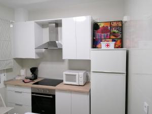 a white kitchen with a refrigerator and a microwave at Alojamiento Dunas centro in Tabernas