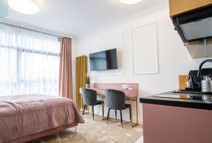 um quarto de hotel com uma cama, uma mesa e cadeiras em ARKA APARTAMENT DELUXE 723b em Kolobrzeg