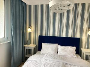 łóżko z niebieskim zagłówkiem w sypialni w obiekcie Tabago Studio 6 w mieście Katowice