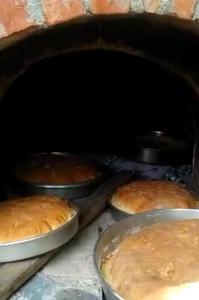 two pans of bread cooking in an oven at Cold Springs in Theth