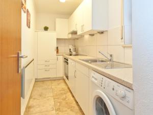 a white kitchen with a sink and a washing machine at Holiday home Reichenbach in Bayerstetten
