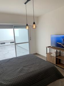 a bedroom with a bed and a flat screen tv at Luminoso monoambiente en Rosario in Rosario