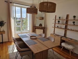 a dining room with a wooden table and chairs at Appartement Enghien-les-Bains in Enghien-les-Bains