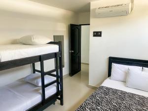 a room with two bunk beds in a room at Hostal Viña del Mar in Taganga