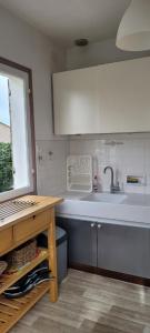 a kitchen with a sink and a large tub at La petite maison de Meschers in Meschers-sur-Gironde