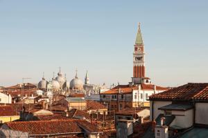 uma vista para uma cidade com uma torre de relógio e telhados em Altana Rialto Apartment em Veneza