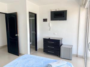 a bedroom with a bed and a dresser and a mirror at Hostal Viña del Mar in Taganga