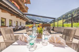 a table with wine glasses and flowers on a patio at Galtenberg Bed & Breakfast in Alpbach +22 photos