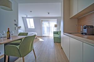 Aparthotel Bad Radkersburg في باد رادكرسبرغ: مطبخ وغرفة معيشة مع طاولة وكراسي