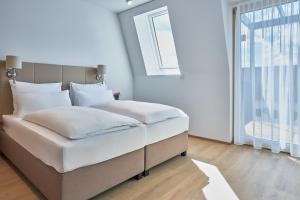 Schlafzimmer mit einem großen weißen Bett und einem Fenster in der Unterkunft Aparthotel Bad Radkersburg in Bad Radkersburg