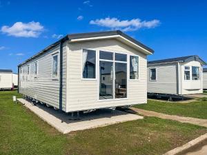 a white tiny house sitting in a yard at Lovely 8 Berth Caravan For Hire At Barmston Beach Holiday Park Ref 62002o in Lund