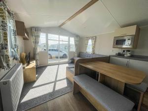 a small kitchen with a table and a dining room at Lovely 8 Berth Caravan For Hire At Barmston Beach Holiday Park Ref 62002o in Lund