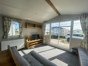 a living room with a couch and a tv and windows at Lovely 8 Berth Caravan For Hire At Barmston Beach Holiday Park Ref 62002o in Lund