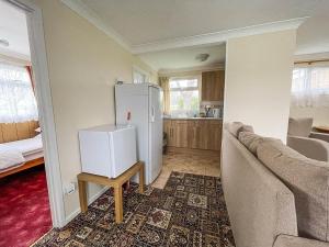 a living room with a refrigerator and a couch at Superb Chalet In Nearby Hemsby Beach In Norfolk With Free Wifi Ref 00122ba in Hemsby