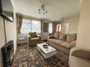 a living room with a couch and a table at Superb Chalet In Nearby Hemsby Beach In Norfolk With Free Wifi Ref 00122ba in Hemsby