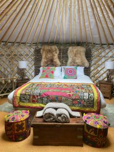 A bed or beds in a room at HAYNE BARN ESTATE - 2 Luxury heated Yurts - private hot tub- private bathroom and kitchen