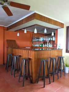 a bar with stools in a room at Puesta del sol Beach Bungalows and Restobar in Abu