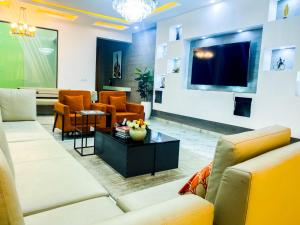 a living room with couches and a tv and chairs at Impeccable 2-Bed Apartment in Lekki With Snooker in Lekki
