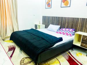a bedroom with a bed with a blue blanket on it at Impeccable 2-Bed Apartment in Lekki With Snooker in Lekki