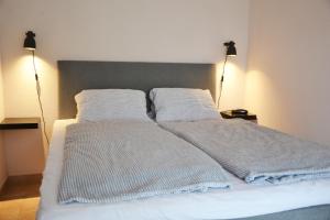 Una cama blanca con dos almohadas encima. en Anna Apartment, en Budaörs