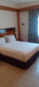 a large bed in a room with a large white bedsheet at Holiday Inn Accra Airport, an IHG Hotel in Accra