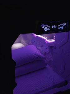 un letto con illuminazione viola in una camera oscura di Planet 23 a Città di Chiayi